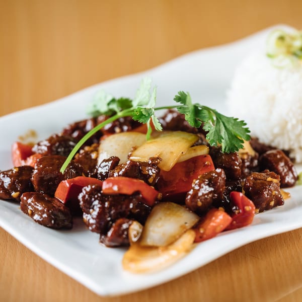 Shaking beef (Bo Luc Lac) with bell peppers, onions, and cilantro, served with white rice.